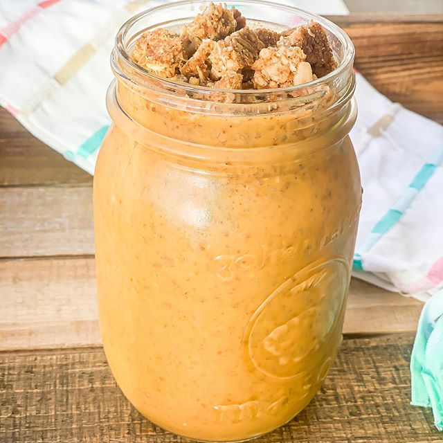 Pumpkin pie chia pudding in a mason jar served with granola on top.